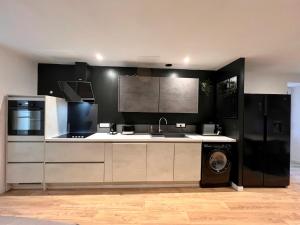 a kitchen with black and white appliances and a washer at LA PALMERAIE -wifi fibre- centre ville -PROPERTY RENTAL NM in Fontenay-le-Comte
