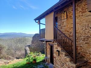 Espinoso de Compludo的住宿－Casa Rural del Acebo，石头房子的一侧设有阳台