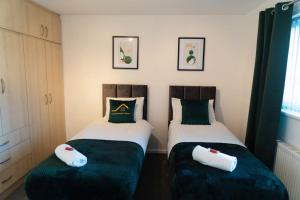 ソリフルにあるSolihull 5 Bed Home near NEC/Bham airport/JLR/HS2のベッド2台が隣同士に設置された部屋です。