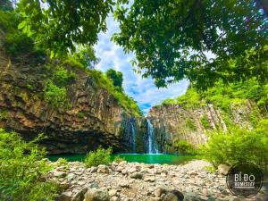uma cascata num desfiladeiro com uma piscina de água em Bí Đỏ homestay em Tuy Hoa