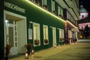 a green building with lights on the side of a street at AKTIVHOTEL Weisser Hirsch in Mariazell