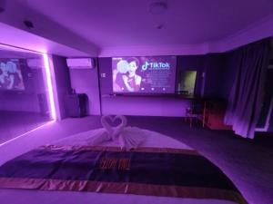 Cette chambre violette comprend un lit et une télévision. dans l'établissement Tina 2 Hotel, à Cái Răng
