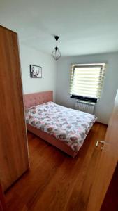 a bedroom with a bed and a window at Apartman Stan ,Istocno Sarajevo 26 in Donje Mladice