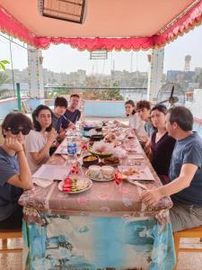un grupo de personas sentadas alrededor de una mesa comiendo comida en Nuba Dool en Asuán