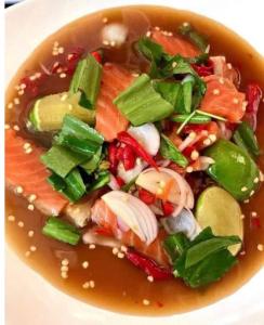 a bowl of soup with salmon and other vegetables at ANGEL RESORT i in Amphoe Sawang Daen Din