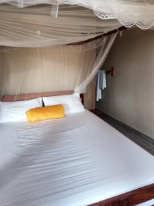 a bed with a yellow blanket on top of it at NAMU Apartments in Katima Mulilo