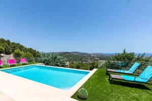 une villa avec une piscine et deux chaises longues dans l'établissement Altamar, à Calp