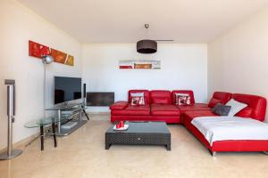 - un salon avec un canapé rouge et une télévision dans l'établissement Altamar, à Calp