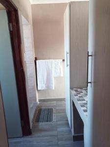 ein Bad mit einer Dusche und einem Handtuch am Fenster in der Unterkunft NAMU Apartments in Katima Mulilo