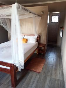 a bedroom with a canopy bed and a wooden floor at NAMU Apartments in Katima Mulilo