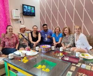 um grupo de pessoas sentadas à volta de uma mesa em Friends Home Stay - Agra em Agra