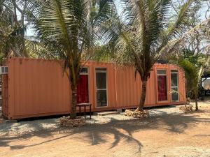 ein Haus mit zwei Palmen davor in der Unterkunft INNBOX CAMPSITE in Bolinao