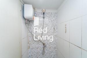 a bathroom with a shower with a red dye sign on the wall at RedLiving Apartemen Grand Sentraland - Bangde Rooms in Karawang