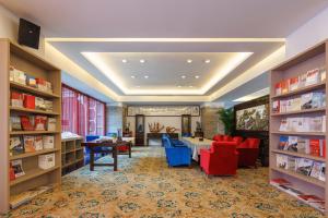 une bibliothèque avec des tables, des chaises et des étagères dans l'établissement Sunflower Hotel & Residence, Shenzhen, à Shenzhen