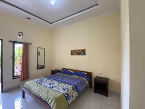 um quarto com uma cama e uma janela em Jero Harum Homestay em Krambitan