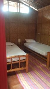 Habitación con 2 camas y alfombra. en Reggae Guesthouse en Panglao City