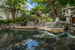 a garden with a pool of water and trees at Kinugawa Grand Hotel Yumenotoki in Nikko