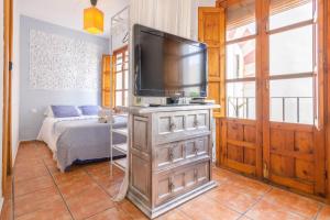 a room with a television on a dresser with a bed at Apartamento Ilusión Andaluza in Córdoba