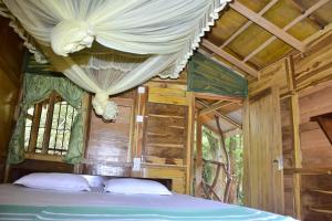 um quarto com uma cama de dossel e janelas em Wilpattu Jungle Resort em Nochchiyagama