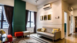a living room with a couch and a green wall at Arte Plus Jalan Ampang by Airhost in Kuala Lumpur