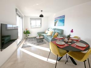 sala de estar con mesa y sofá azul en Modern 3 Bedroom 7 Guests Sun Golf Beach Apartments, en Villacosta
