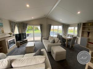 - un salon avec des canapés, une télévision et une table dans l'établissement The Retreat 1 - Hot tub Lodge, pet friendly, WiFi & bed linen- Golden Palm Resort - Meadow Lakes Caravan & Lodge Hire, à Chapel St. Leonards