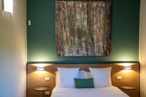 フィウメフレッド・ディ・シチーリアにあるFeudogrande Bio Relais Hotelのベッドルーム1室(ベッド1台、上に絵画付)