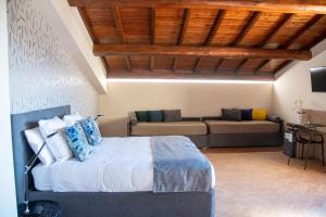 a bedroom with a bed and a couch at Feudogrande Bio Relais Hotel in Fiumefreddo di Sicilia