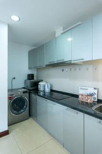 uma cozinha branca com uma máquina de lavar roupa e uma máquina de lavar louça em Vinhomes Royal city apartment 3 bed room em Hanói