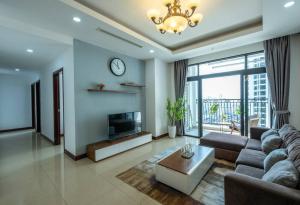 uma sala de estar com um sofá e uma televisão e um relógio em Vinhomes Royal city apartment 3 bed room em Hanói