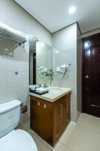 uma casa de banho com um WC, um lavatório e um espelho. em Vinhomes Royal city apartment 3 bed room em Hanói
