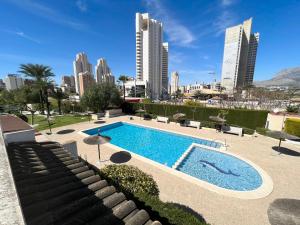 a swimming pool with a city skyline in the background at Rey Don Jaime in Benidorm