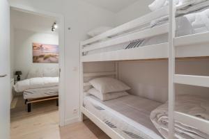 a bedroom with two bunk beds with white walls at Maison les Bruyères 1 - Luxueus wonen Blankenberge in Blankenberge