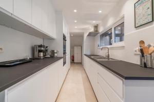a kitchen with white cabinets and black counter tops at Maison les Bruyères 1 - Luxueus wonen Blankenberge in Blankenberge +15 photos
