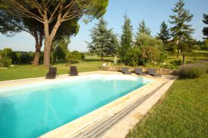 una piscina con sedie a sdraio in un cortile di Chambres d'hôtes - Villa CARPE DIEM TOLOSA a Vieille-Toulouse