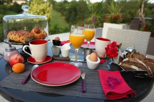 - Mesa con desayuno de huevos, pan y zumo de naranja en Chambres d'hôtes - Villa CARPE DIEM TOLOSA, en Vieille-Toulouse