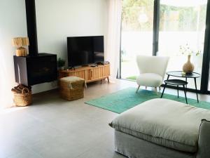 a living room with a couch and a tv at Villa Au Bain Marie in São Martinho do Porto