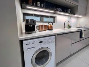 a kitchen with a washer and dryer on a counter at The Pier no. 7 in Swakopmund