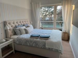 ミエンジズドロイェにあるMorski Apartament Hampton w Playa Baltisのベッドルーム1室(枕付きのベッド1台、窓付)