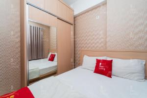 um pequeno quarto com uma cama e um espelho em RedLiving Apartemen Tamansari Panoramic - Rasya Room with Netflix em Bandung
