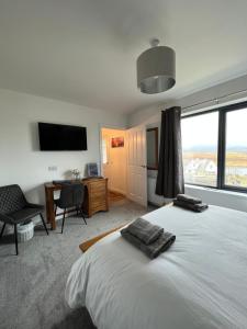 a bedroom with a bed and a desk and a television at Sgothan Dearg in Portree
