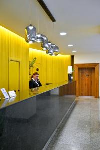 a woman sitting at a reception desk in a lobby at Europe Hotel in Yerevan