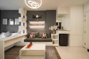 un salon avec un canapé et une table dans l'établissement Vinhomes Smartcity-Zhomestay-Căn hộ dich vụ, à Thượng Thôn