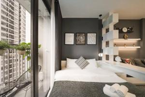 une chambre avec un lit blanc et un balcon dans l'établissement Vinhomes Smartcity-Zhomestay-Căn hộ dich vụ, à Thượng Thôn 2 autres photos