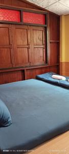 Duas camas num quarto com armários de madeira em Chanmuang guesthouse em Mae Hong Son