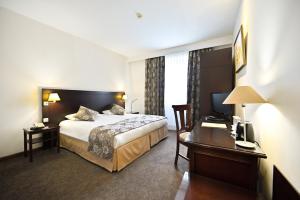 エレバンにあるEurope Hotelのベッドとデスクが備わるホテルルームです。