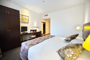 una camera d'albergo con un grande letto e una TV di Europe Hotel a Yerevan