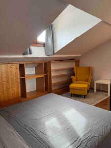 ein Schlafzimmer mit einem Bett und einem gelben Stuhl in der Unterkunft Este Stay in Este