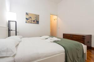 een slaapkamer met een wit bed en handdoeken bij Hideout at Porta Romana in Milaan