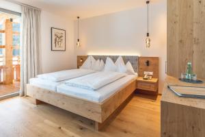 Postel nebo postele na pokoji v ubytování Das Leonhard - Naturparkhotel am Weissensee